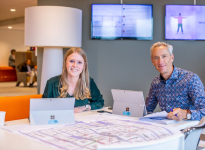 Jonge en oudere gemeentemedewerker samen een een tafel in Pijnacker