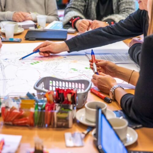 Gemeente Kerkrade handen boven kaart tijdens vergadering